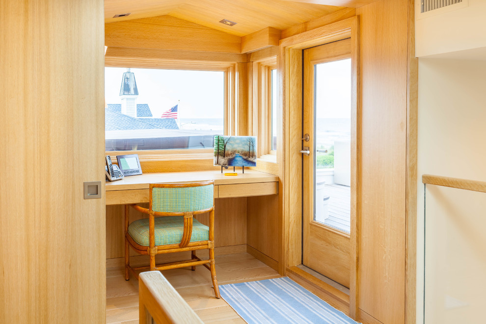 Ejemplo de despacho contemporáneo con paredes beige, suelo de madera clara y escritorio empotrado