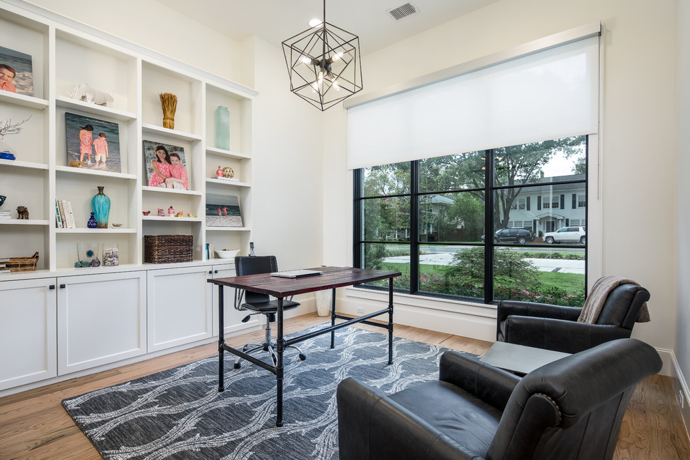 Country Arbeitszimmer mit weißer Wandfarbe, braunem Holzboden, freistehendem Schreibtisch und braunem Boden in Dallas