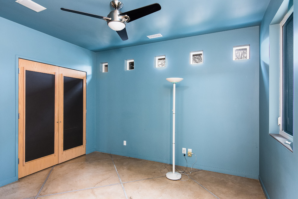 This is an example of a large contemporary study in Portland with concrete flooring, beige floors and blue walls.