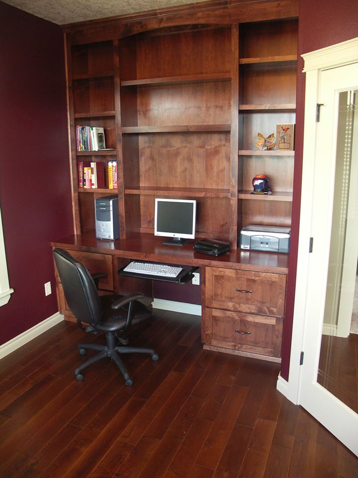 Home office in Portland with red walls, a built-in desk and brown floors.