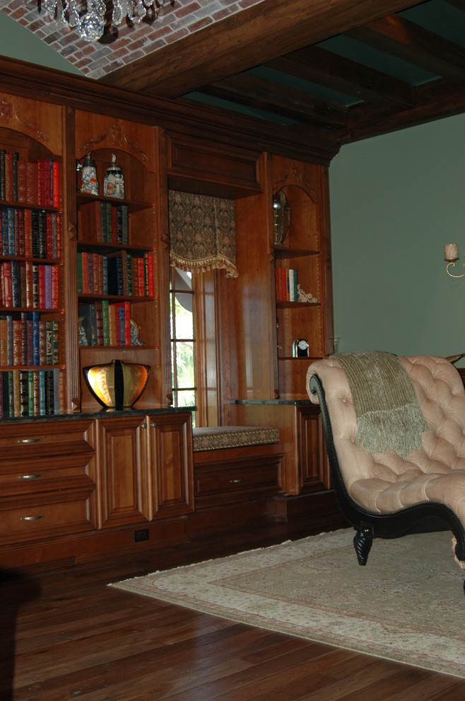 Example of a large classic dark wood floor and brown floor home office library design in Other with green walls and no fireplace
