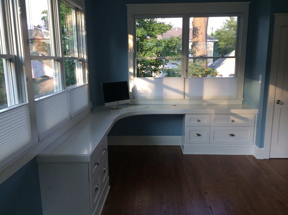Diseño de despacho tradicional renovado grande sin chimenea con paredes azules, suelo de madera oscura, escritorio empotrado y suelo marrón