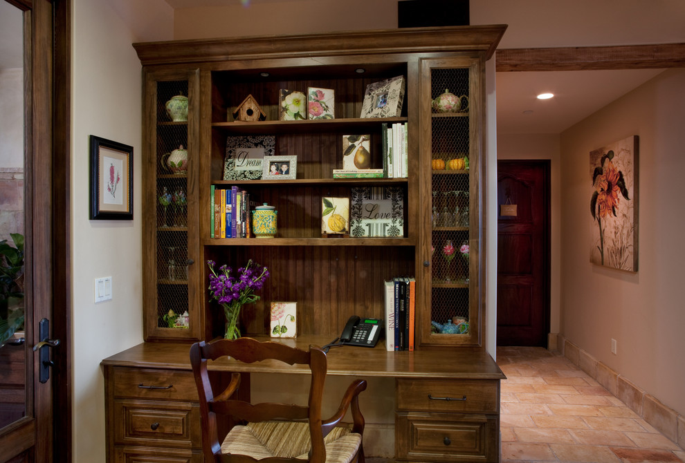Photo of a large mediterranean home office in San Diego with beige walls, terracotta flooring and a freestanding desk.