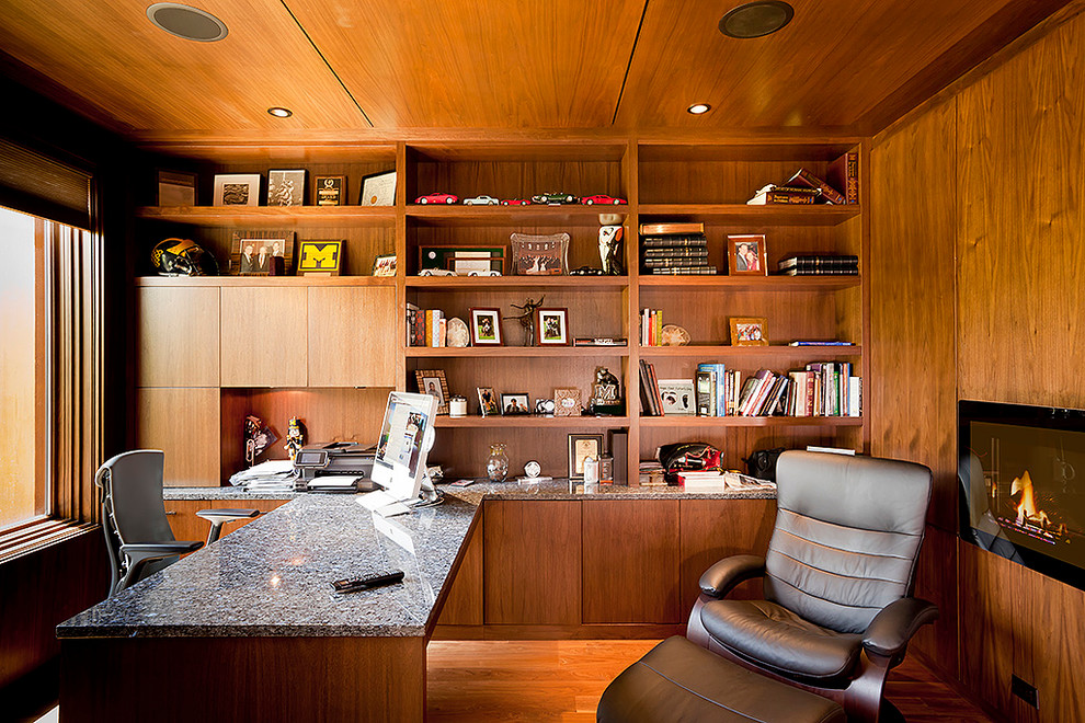 Idee per un ufficio minimal di medie dimensioni con pareti marroni, pavimento in legno massello medio, camino lineare Ribbon e scrivania incassata