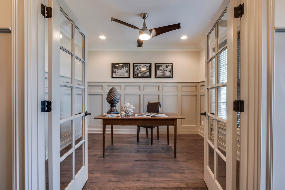 Ejemplo de despacho contemporáneo grande sin chimenea con paredes beige, suelo de madera en tonos medios y escritorio independiente