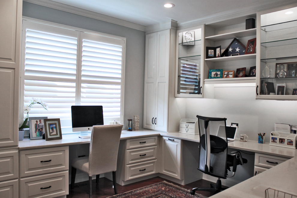Immagine di un ufficio minimal di medie dimensioni con pareti blu, parquet scuro, nessun camino e scrivania incassata