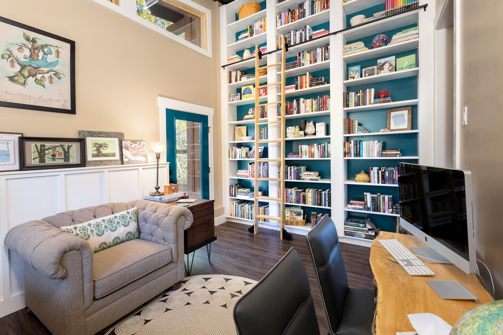На фото: домашняя библиотека в стиле рустика с синими стенами, темным паркетным полом, отдельно стоящим рабочим столом и коричневым полом без камина