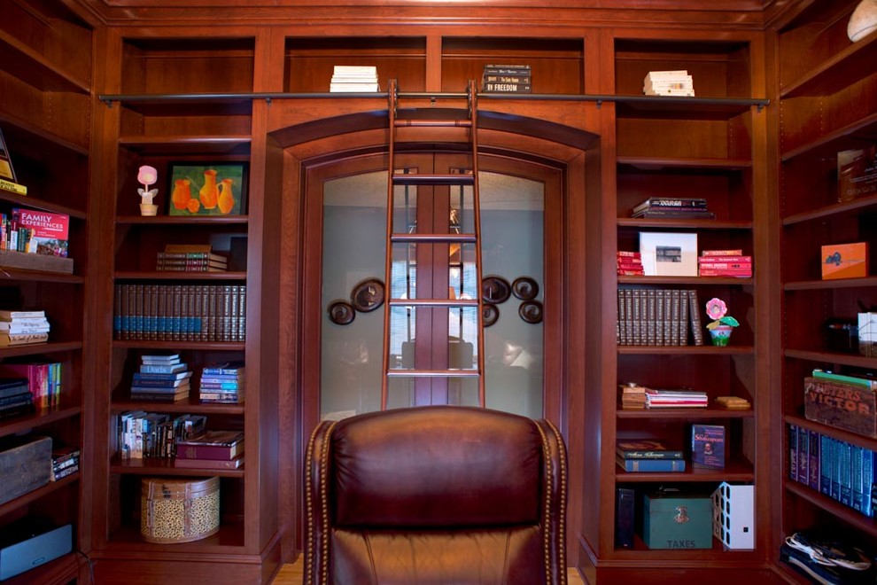 Inspiration for a large classic study in Charlotte with brown walls, light hardwood flooring and a freestanding desk.