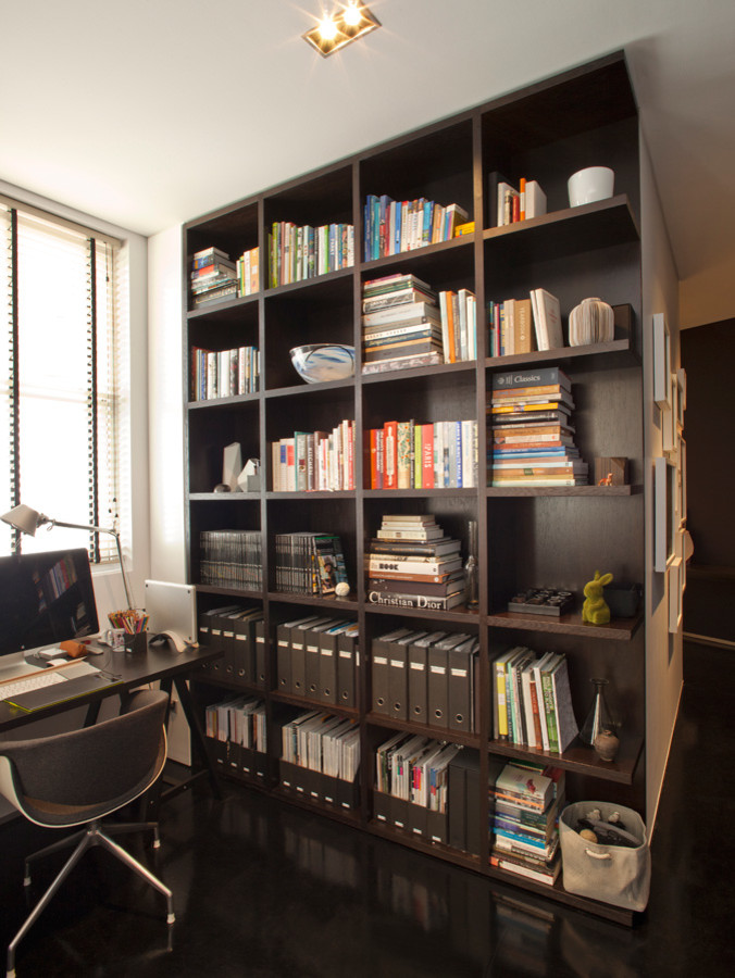 Cette image montre un grand bureau avec une bibliothèque ou un coin lecture et un bureau indépendant.