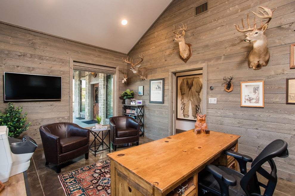 Photo of a medium sized rustic study in Austin with grey walls, concrete flooring, no fireplace, a freestanding desk and grey floors.