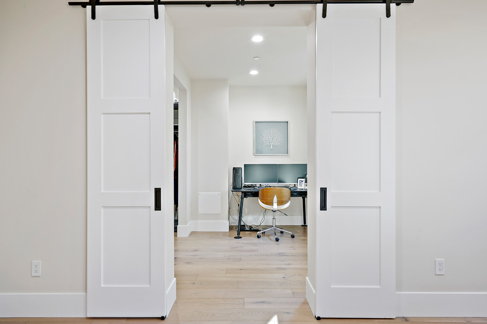 Medium sized modern study in San Francisco with grey walls, light hardwood flooring, no fireplace, a freestanding desk and beige floors.
