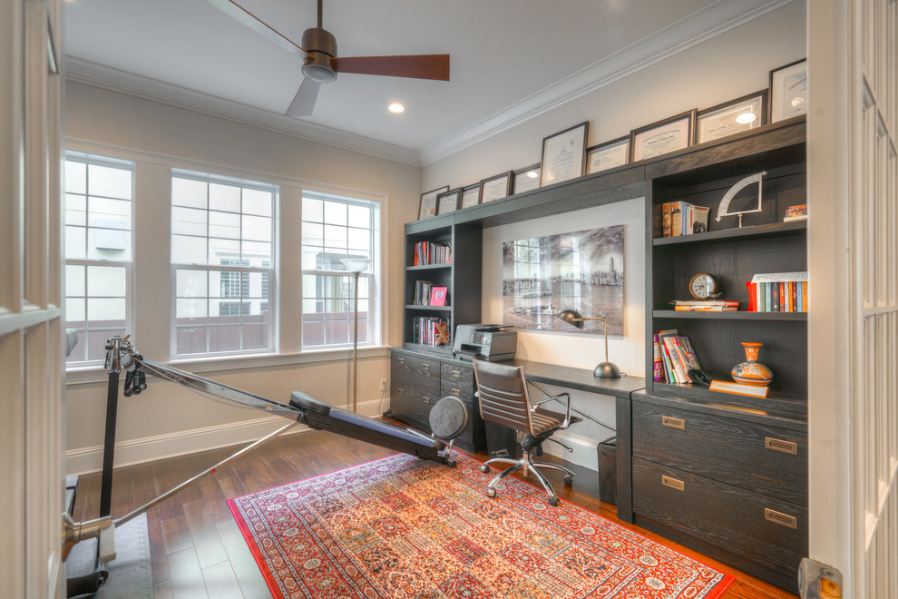 Foto di un grande ufficio tradizionale con pareti beige, pavimento in legno massello medio, nessun camino, scrivania autoportante e pavimento marrone