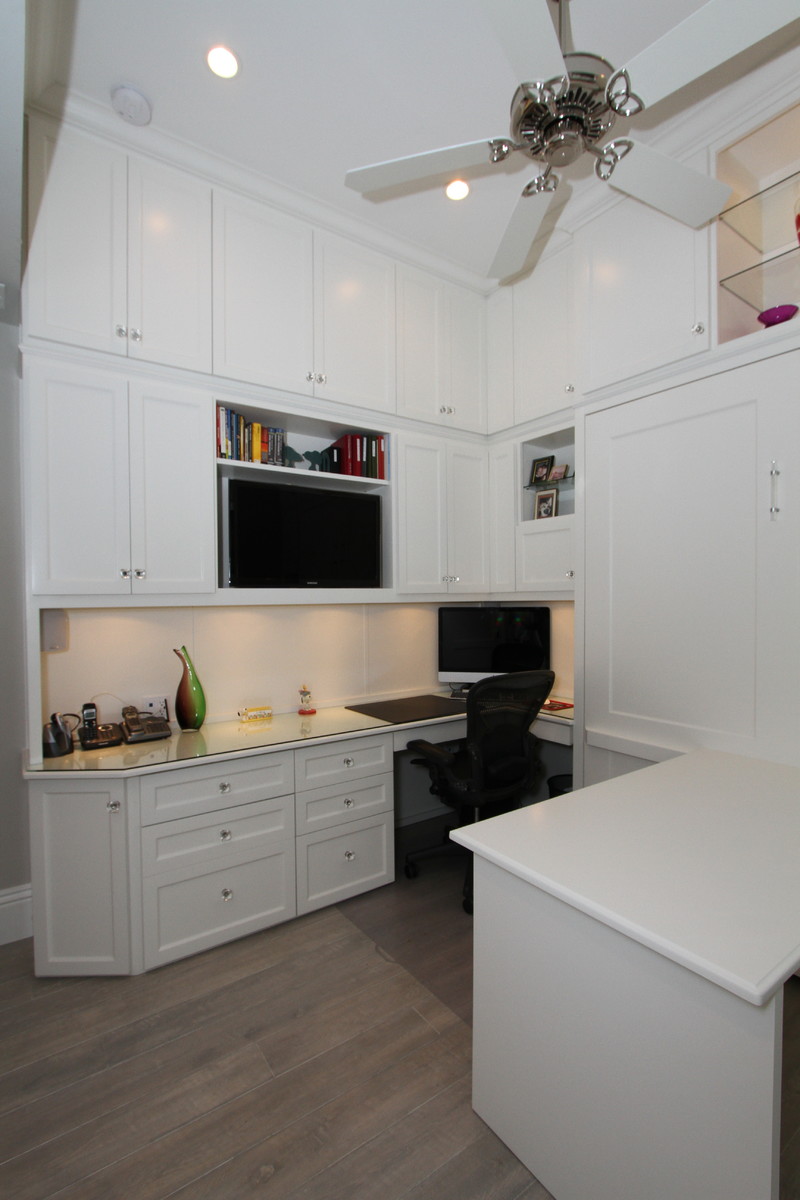 Cette image montre un bureau atelier traditionnel de taille moyenne avec un mur gris, parquet clair, un bureau intégré et un sol gris.