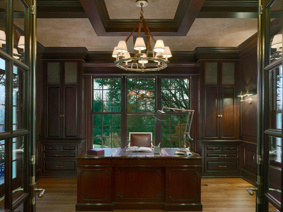 Imagen de despacho clásico renovado grande sin chimenea con paredes marrones, suelo de madera en tonos medios y escritorio independiente