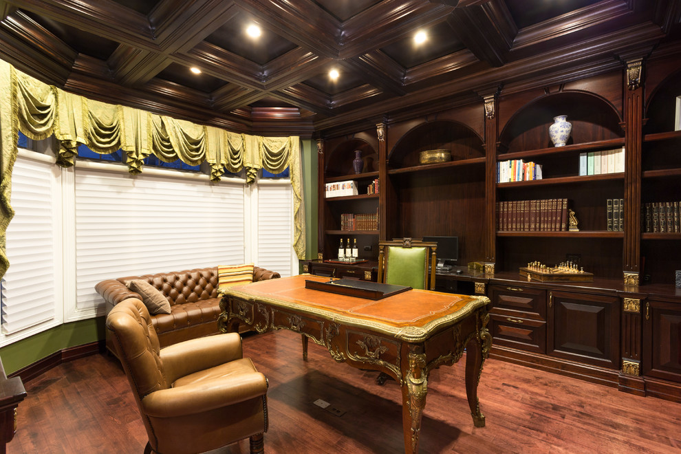 Imagen de despacho clásico de tamaño medio sin chimenea con paredes verdes, suelo de madera clara y escritorio independiente