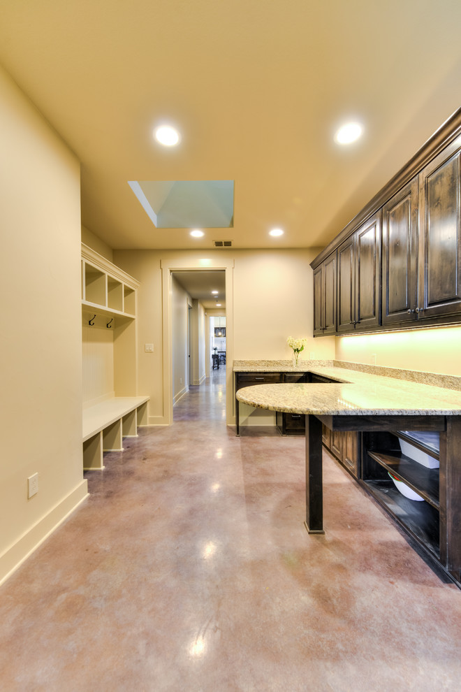Großes Arbeitszimmer mit beiger Wandfarbe, Betonboden und Einbau-Schreibtisch in Austin