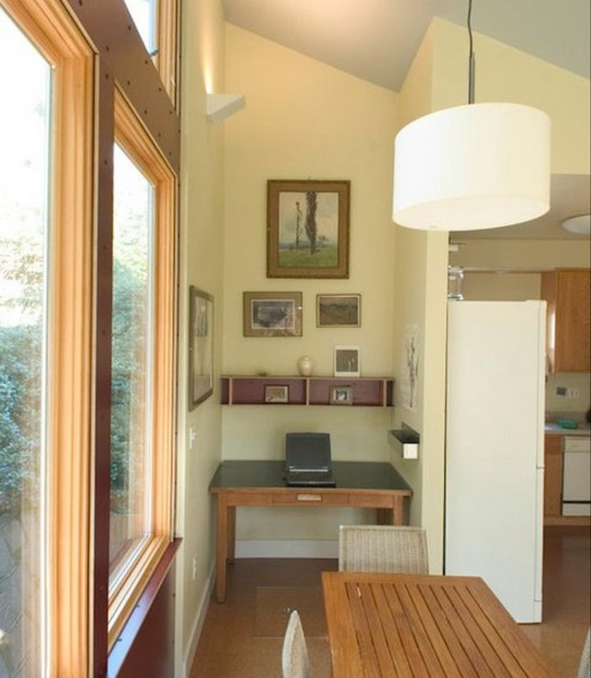 Foto de despacho actual con paredes beige, suelo de madera clara y escritorio empotrado
