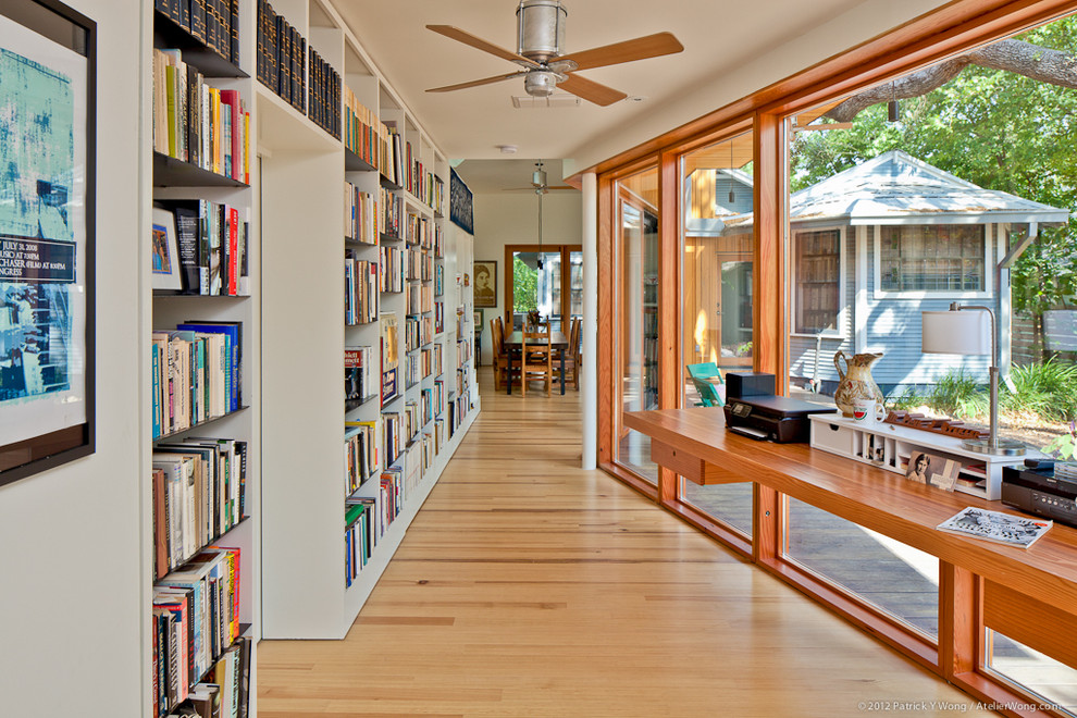 オースティンにあるコンテンポラリースタイルのおしゃれなホームオフィス・書斎 (白い壁、無垢フローリング、造り付け机) の写真