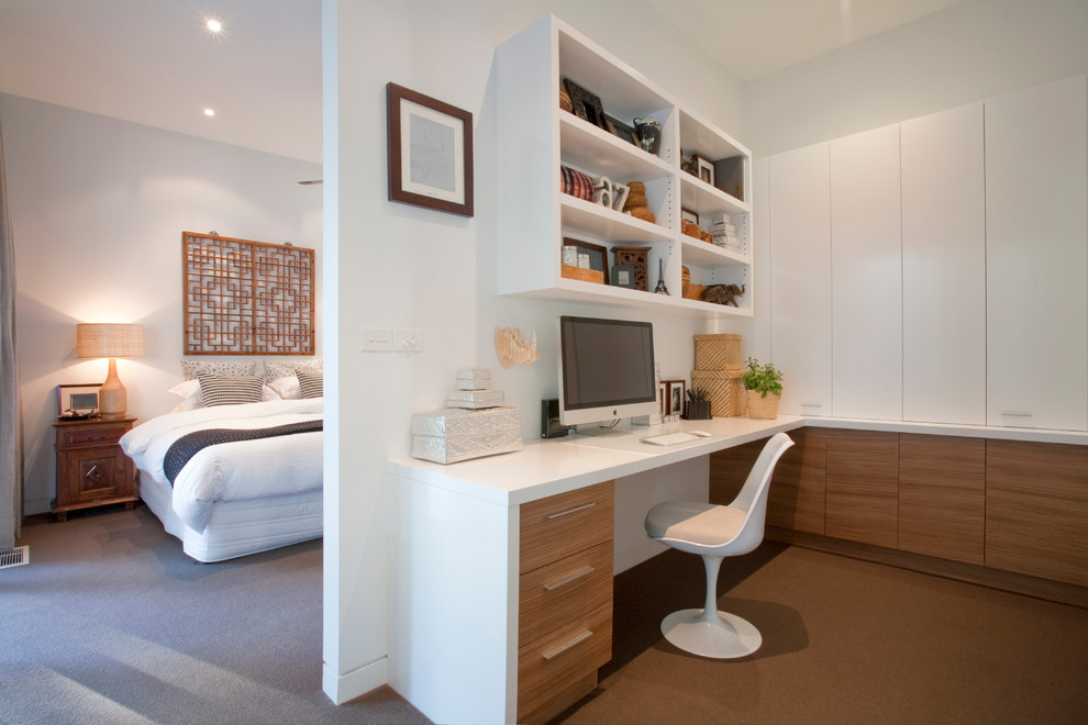 Inspiration för moderna hemmabibliotek, med vita väggar, heltäckningsmatta och ett inbyggt skrivbord