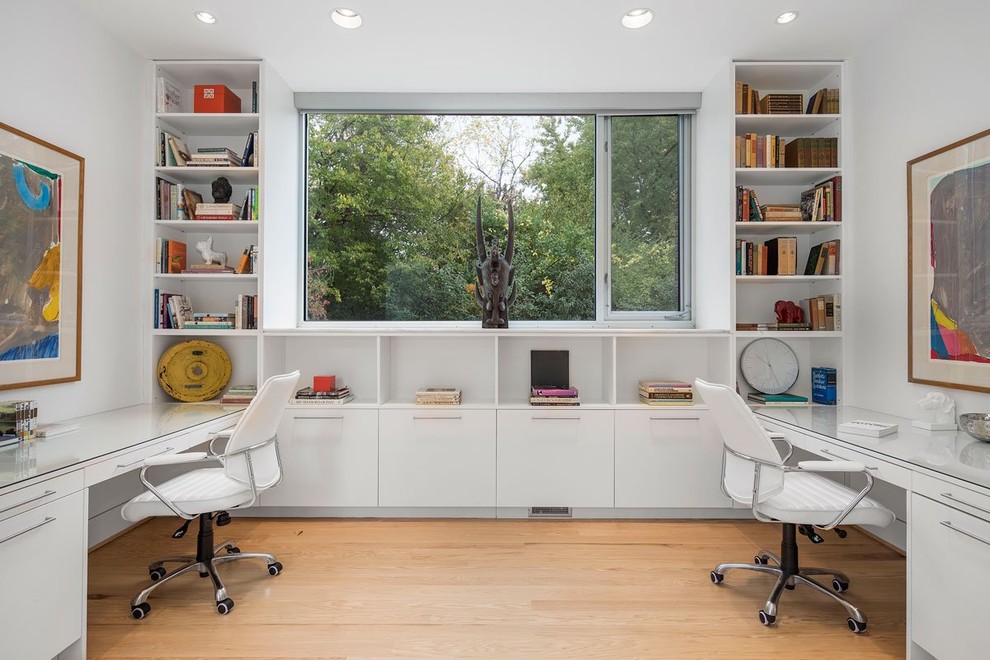Стильный дизайн: большой кабинет в стиле модернизм с белыми стенами и встроенным рабочим столом - последний тренд