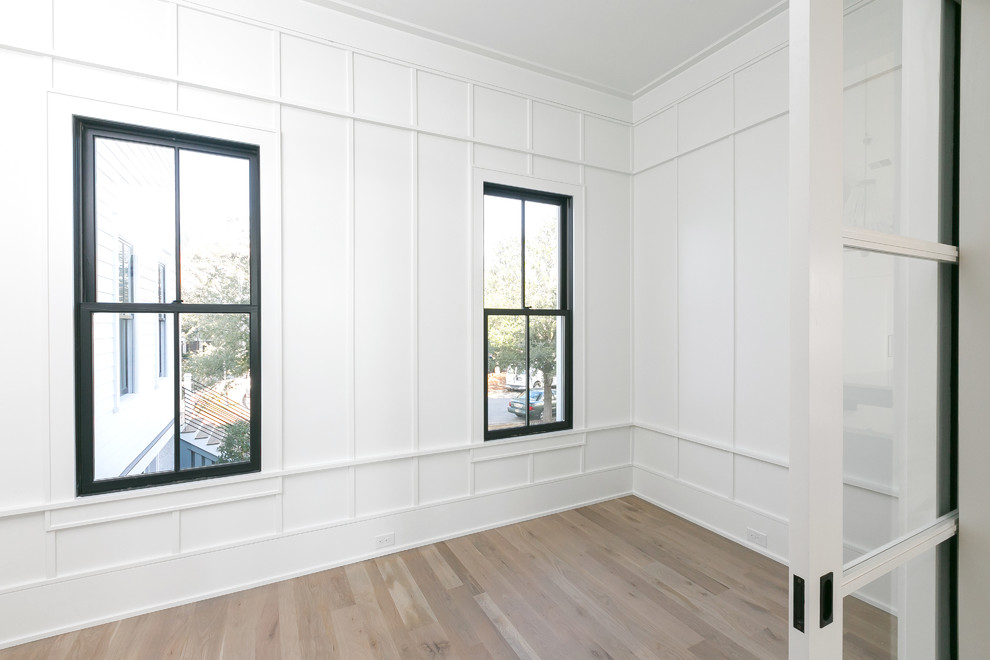 Arbeitszimmer mit weißer Wandfarbe und hellem Holzboden in Charleston