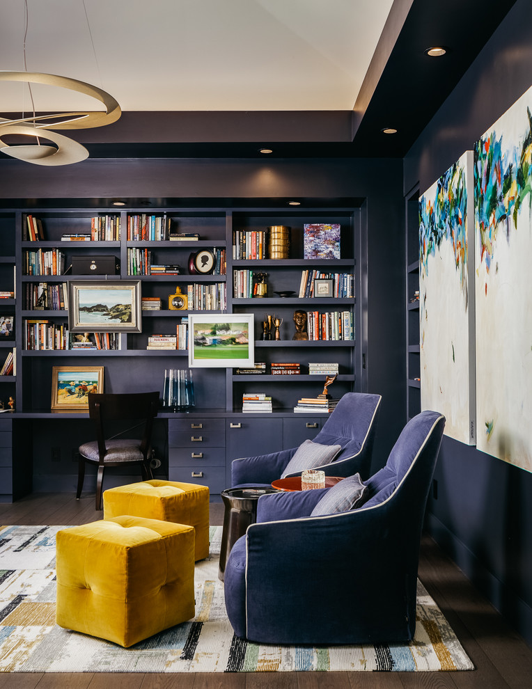 Exempel på ett stort klassiskt arbetsrum, med ett bibliotek, blå väggar, mörkt trägolv, ett inbyggt skrivbord och brunt golv