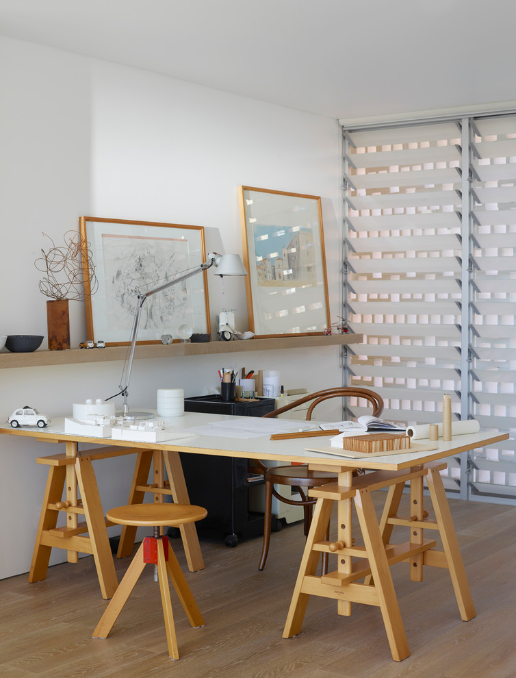 Mittelgroßes Modernes Arbeitszimmer mit Arbeitsplatz, weißer Wandfarbe, hellem Holzboden und freistehendem Schreibtisch in Sydney