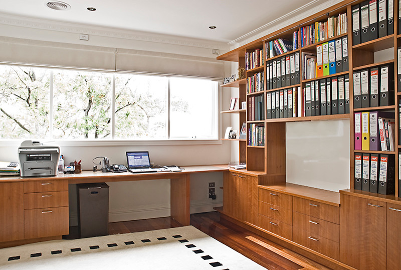 Inspiration for a large contemporary home office in Melbourne with white walls, light hardwood flooring and a built-in desk.