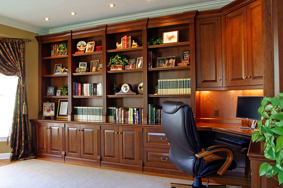 Ejemplo de despacho tradicional grande sin chimenea con paredes beige, suelo de madera clara y escritorio empotrado