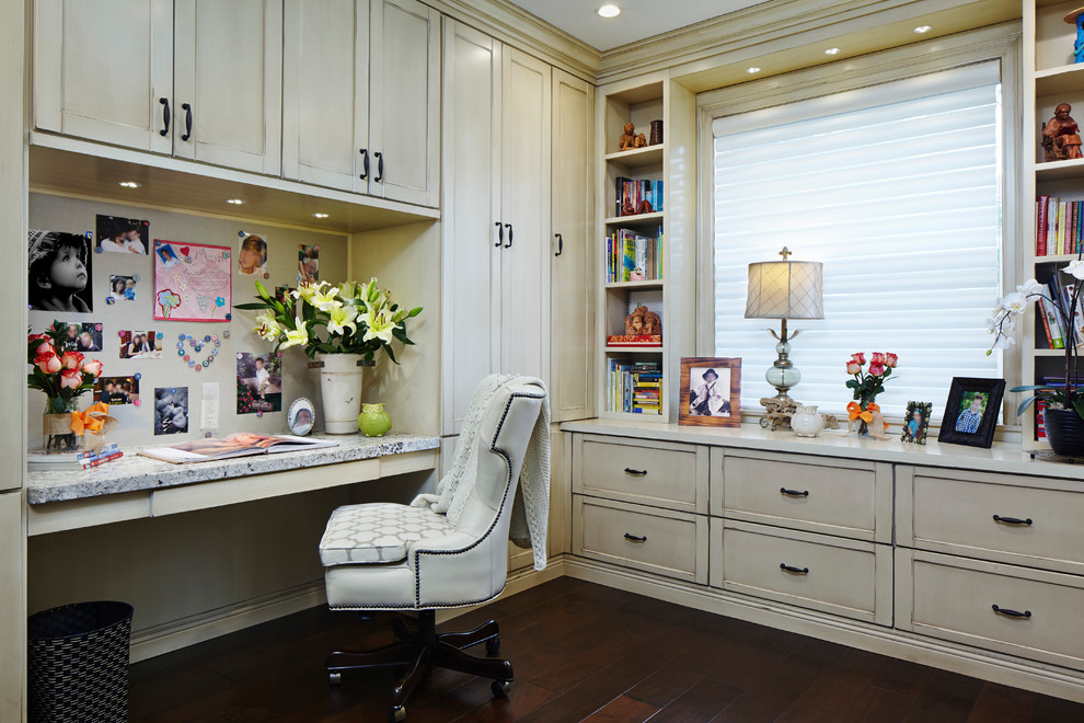 Diseño de despacho clásico renovado grande sin chimenea con paredes beige, suelo de madera oscura y escritorio empotrado