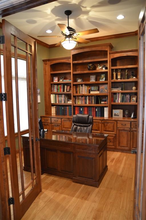 Cette image montre un bureau traditionnel de taille moyenne avec un mur vert, parquet clair, aucune cheminée, un bureau indépendant et un sol beige.