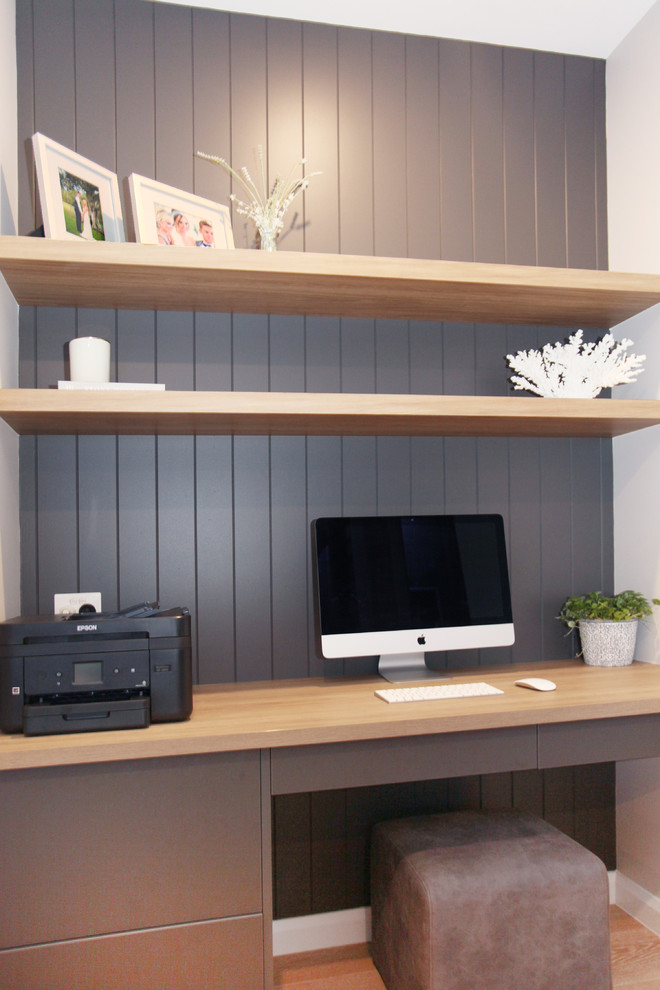 Imagen de despacho costero pequeño con paredes grises, suelo de madera clara, escritorio empotrado y suelo amarillo