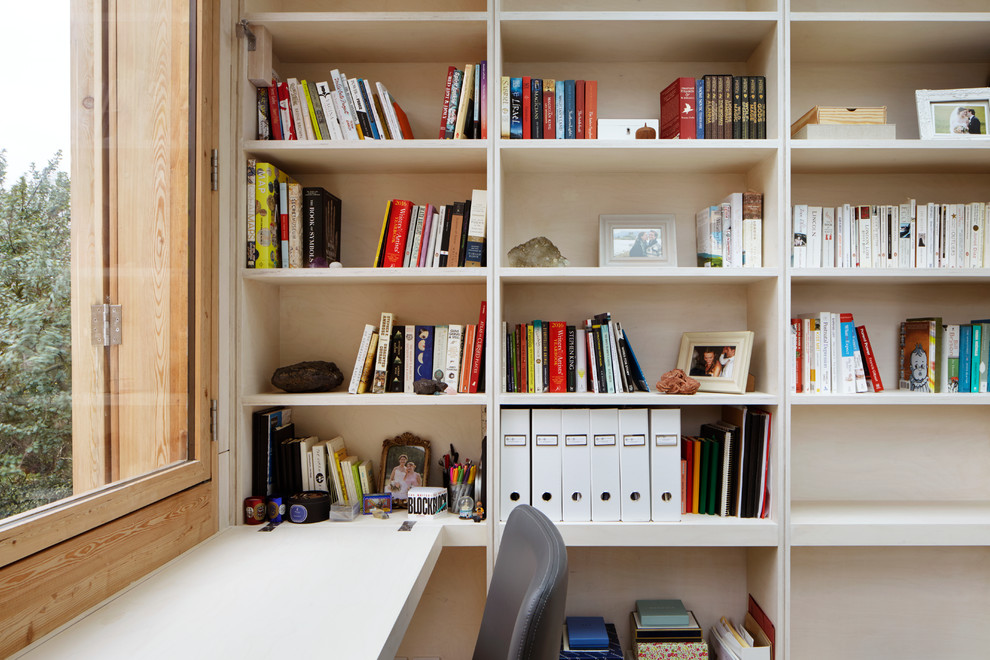 Ejemplo de despacho actual sin chimenea con paredes blancas, suelo de madera clara, escritorio empotrado y suelo marrón