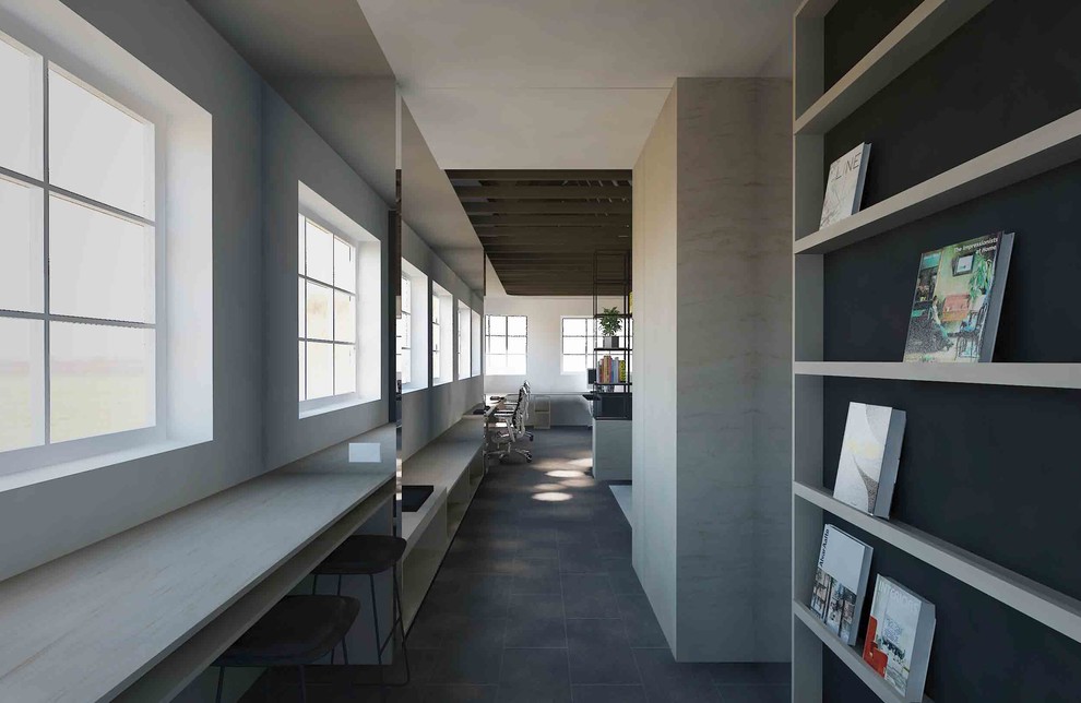 Immagine di un atelier minimalista di medie dimensioni con pareti grigie, pavimento in cemento, scrivania incassata e pavimento grigio
