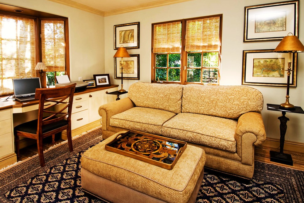 Imagen de despacho clásico de tamaño medio sin chimenea con escritorio empotrado, paredes beige, suelo de madera clara y suelo beige