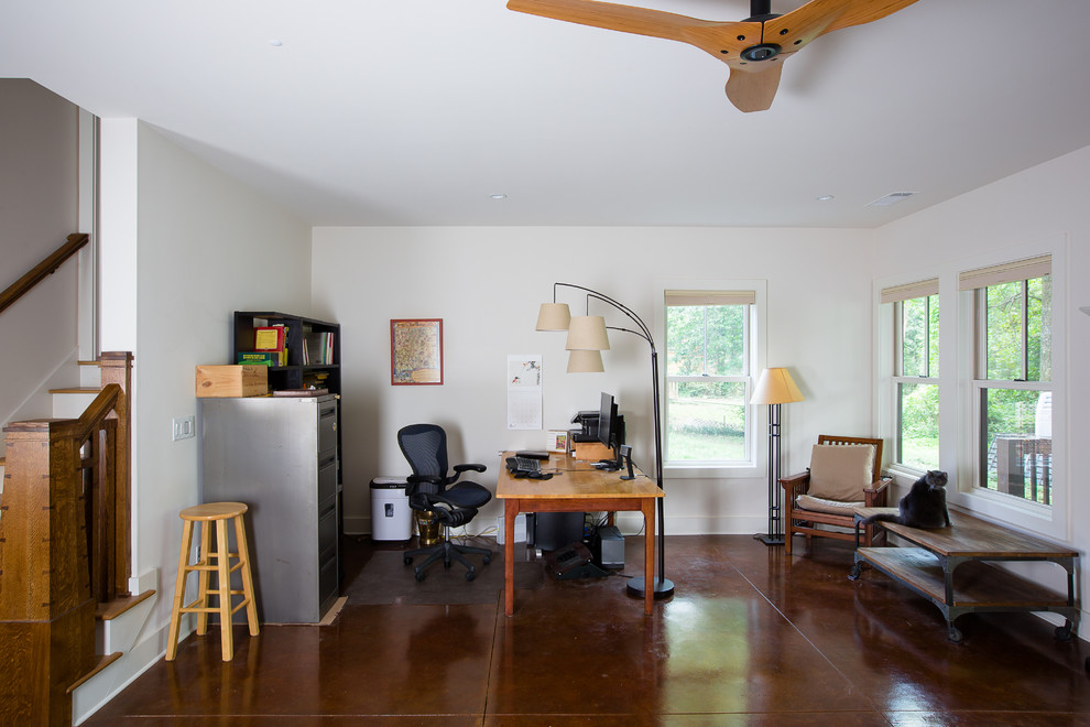 Foto di un ufficio stile americano di medie dimensioni con scrivania autoportante, pavimento in cemento, pareti bianche e pavimento marrone