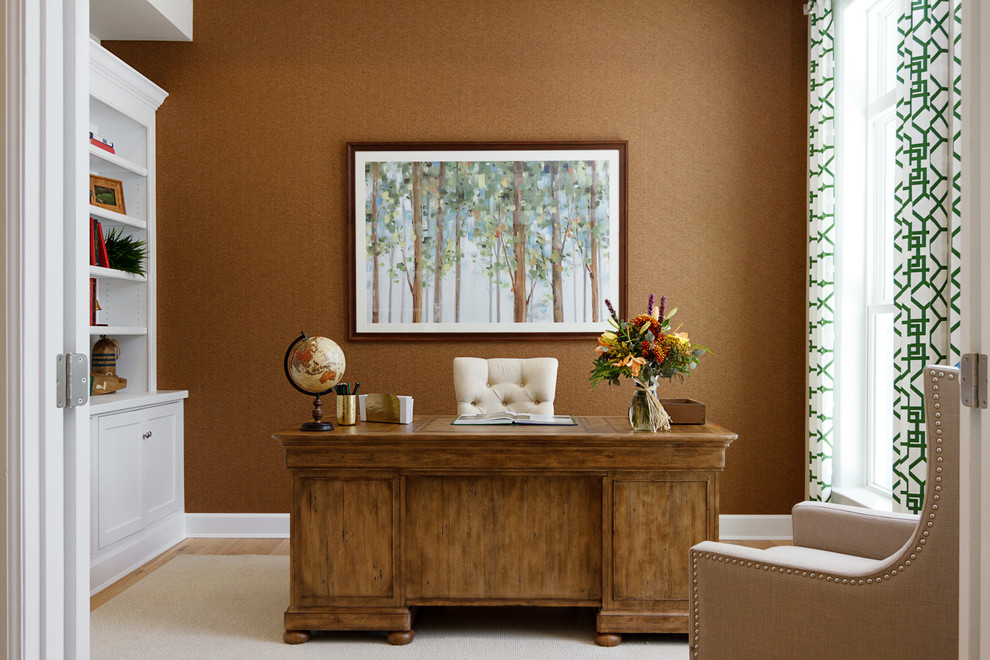 Klassisches Arbeitszimmer mit Arbeitsplatz, brauner Wandfarbe, hellem Holzboden, freistehendem Schreibtisch und braunem Boden in Sonstige