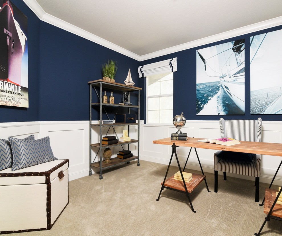Maritim inredning av ett mellanstort hemmabibliotek, med blå väggar, heltäckningsmatta och ett fristående skrivbord