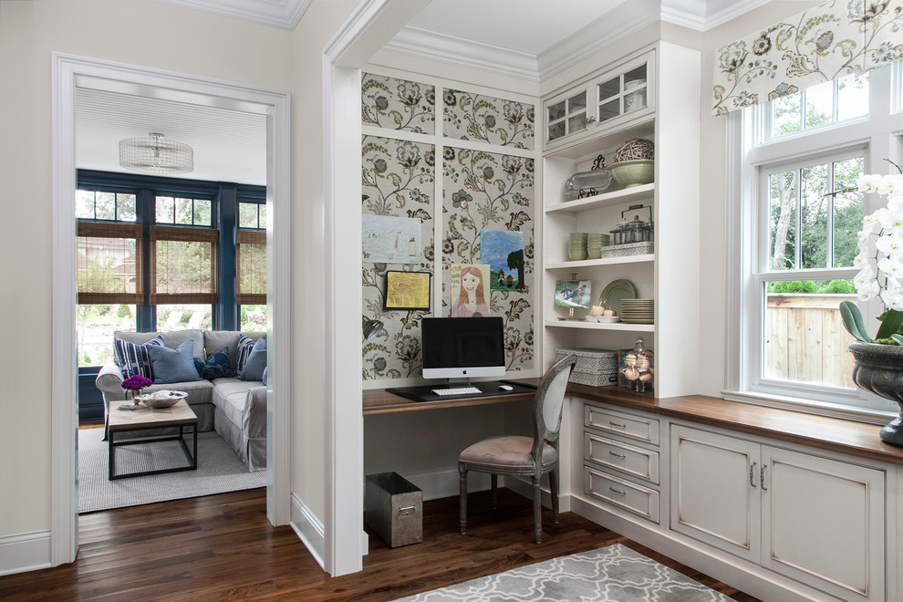 Ejemplo de despacho clásico con paredes beige, suelo de madera oscura y escritorio empotrado