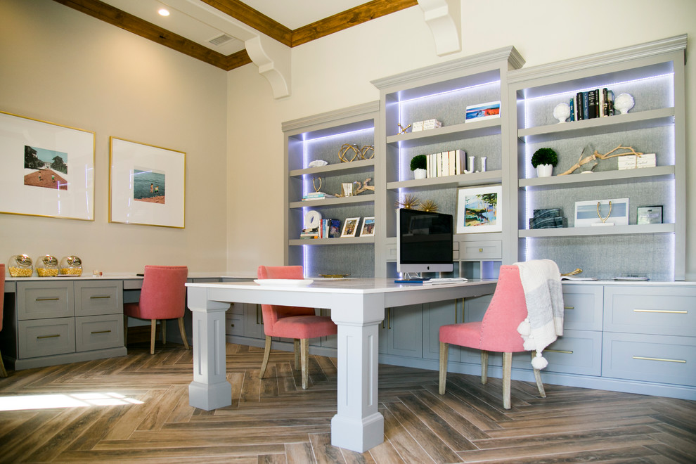 Idéer för att renovera ett mellanstort funkis hemmabibliotek, med vita väggar, mellanmörkt trägolv och ett inbyggt skrivbord