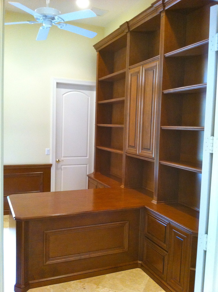 Cette image montre un grand bureau traditionnel avec une bibliothèque ou un coin lecture, un mur beige, un sol en carrelage de céramique, un bureau intégré et un sol beige.