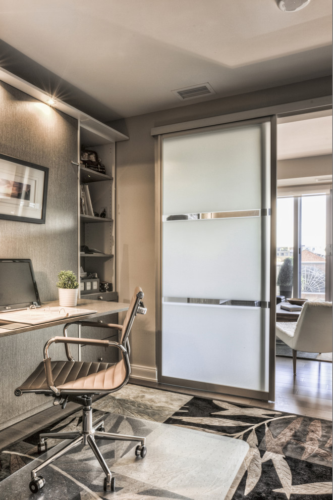 Aménagement d'un petit bureau contemporain avec un mur gris, un sol en bois brun et un bureau intégré.