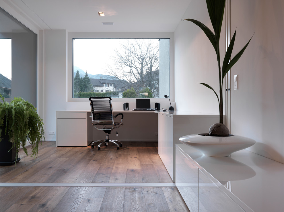 Ispirazione per un ufficio minimalista con pareti bianche, pavimento in legno massello medio, nessun camino e scrivania incassata