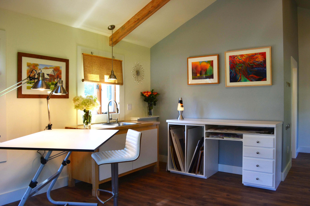 Cette image montre un grand bureau nordique de type studio avec un mur blanc, sol en stratifié, un bureau indépendant et un sol marron.