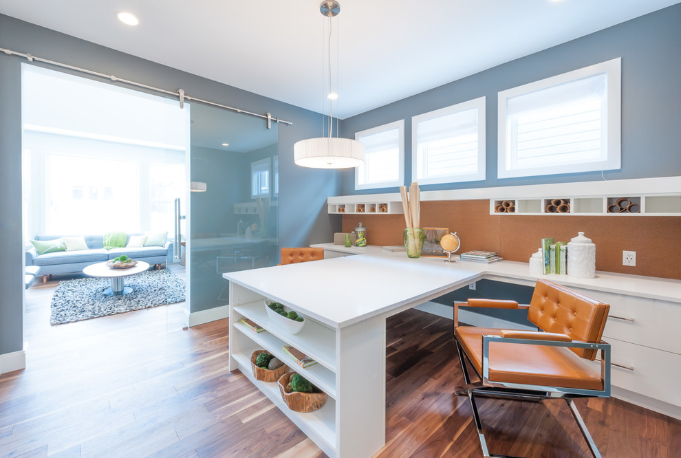 Foto de sala de manualidades contemporánea de tamaño medio con paredes grises, suelo de madera en tonos medios, escritorio empotrado y suelo marrón