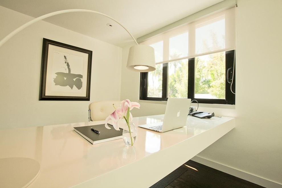 Exemple d'un bureau tendance avec un mur blanc, parquet foncé et un bureau intégré.