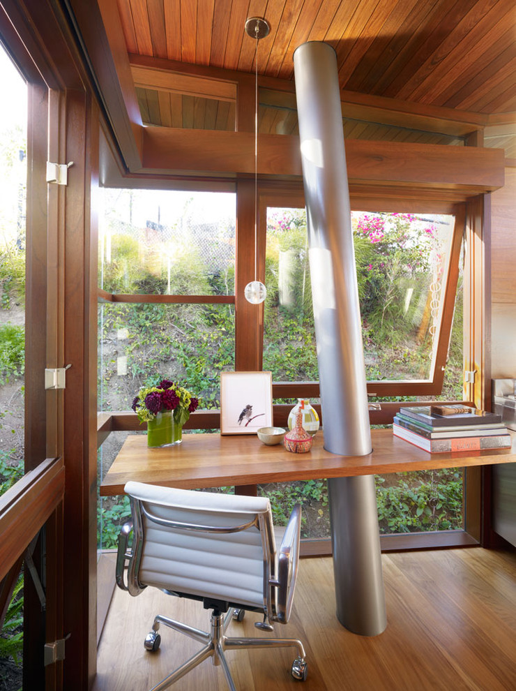 Ejemplo de despacho minimalista con suelo de madera en tonos medios y escritorio empotrado