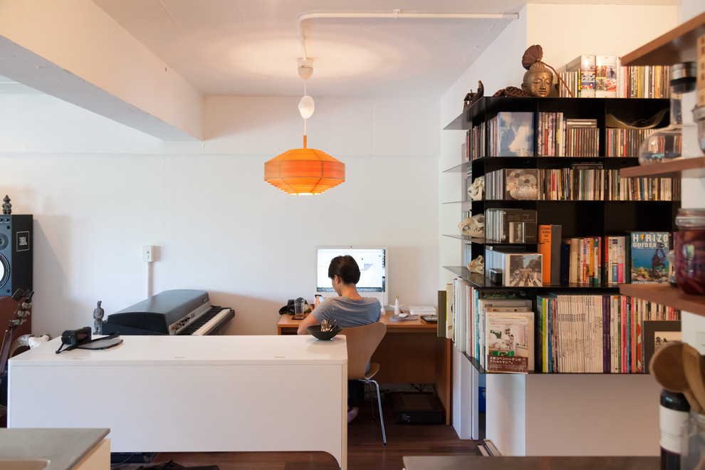 Photo of a small study in Tokyo with white walls, medium hardwood flooring, no fireplace and a freestanding desk.