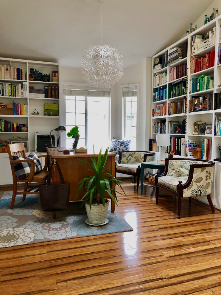 Idée de décoration pour un bureau tradition de taille moyenne avec une bibliothèque ou un coin lecture, un mur blanc, parquet en bambou, un bureau indépendant et un sol marron.