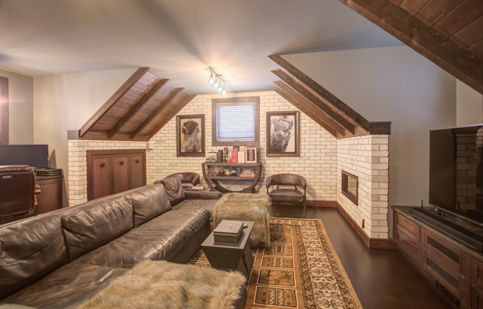 Exemple d'un grand bureau tendance avec un mur gris, une cheminée standard, un manteau de cheminée en brique, un bureau intégré et un sol marron.